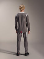 Alpinestars A-Dura Dri Wool Jersey - Long Sleeve, Dark Gray, rear view on model, featuring light gray mesh panels on shoulders and collar, dropped tail hem with a small red brand tag, worn with matching gray cycling pants.