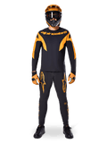 MTB rider wearing Alpinestars A-Supra Race Jersey - Long Sleeve in Black and Orange, matching black and orange pants, gloves, and a full-face helmet with goggles, coordinated mountain bike kit for racing and off-road performance