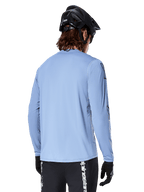 Alpinestars A-Dura Switch Long Sleeve Jersey, Infinity Blue, rear view of mountain bike rider wearing a black helmet and shorts, casual performance cycling apparel with a drop-tail hem.