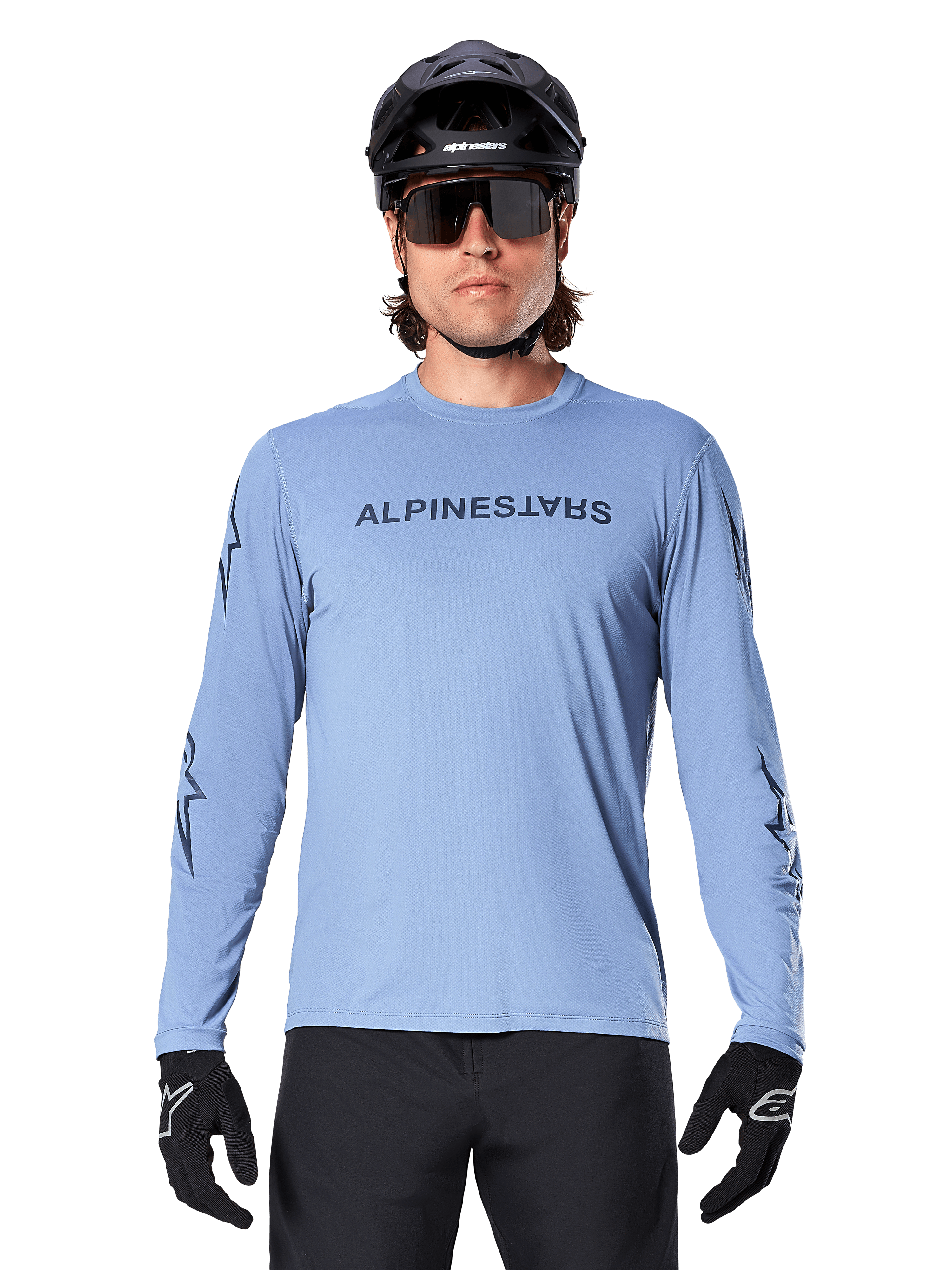 Alpinestars A-Dura Switch Long Sleeve Jersey, Infinity Blue, worn by a man with a black MTB helmet and sunglasses, featuring chest wordmark and sleeve graphics, performance mountain bike apparel