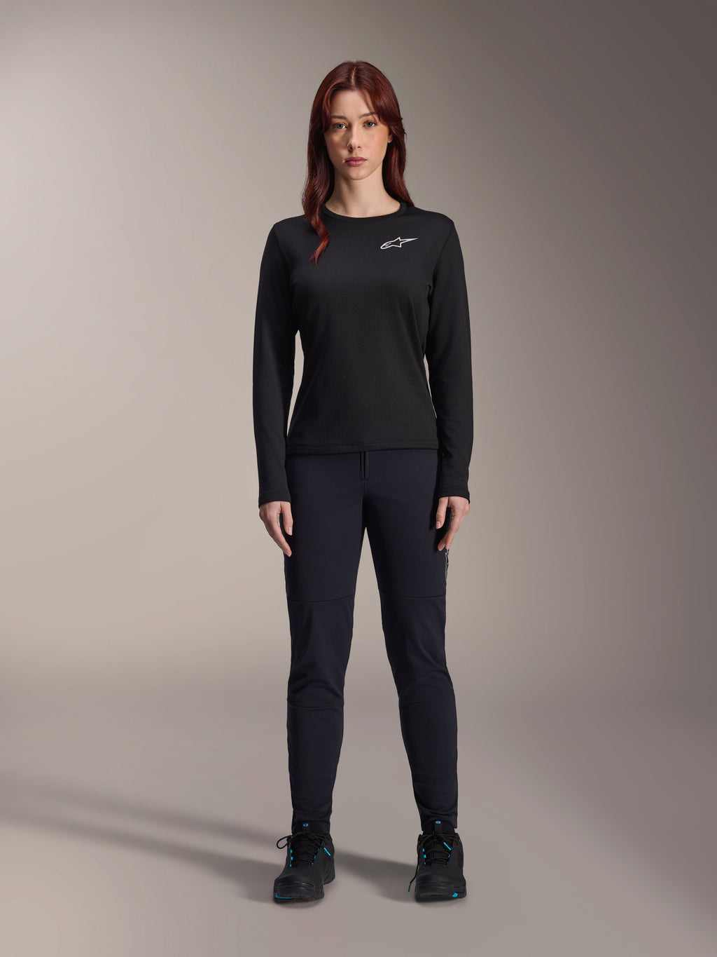 Alpinestars Stella A-Dura Thermal Jersey, Woman's Long-Sleeve Mountain Bike Jersey in Black, featuring a white chest logo, worn with matching black gear and cycling shoes, studio portrait.