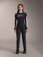 Woman wearing Alpinestars Stella A-Dura Dri Astar Long Sleeve Jersey, Black with white chest logo and light-colored mesh sleeve panels, paired with black pants and black shoes, technical mountain bike apparel