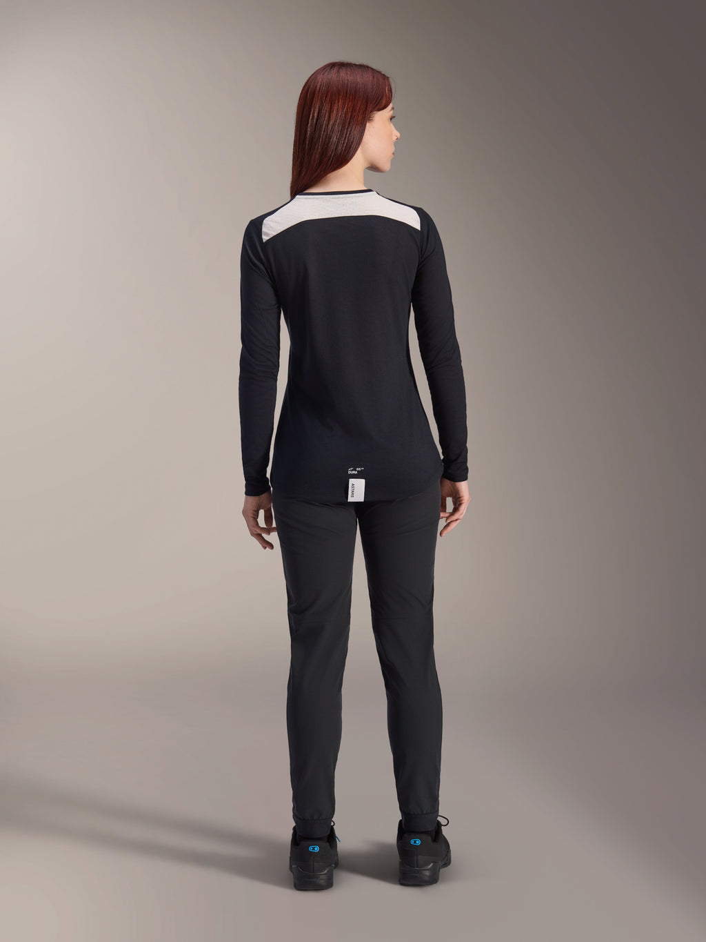 Alpinestars Stella A-Dura Dri Astar Long Sleeve Jersey, Women's Black MTB Jersey, rear view featuring white mesh ventilation panel on shoulders, paired with black cycling pants, technical off-road riding apparel
