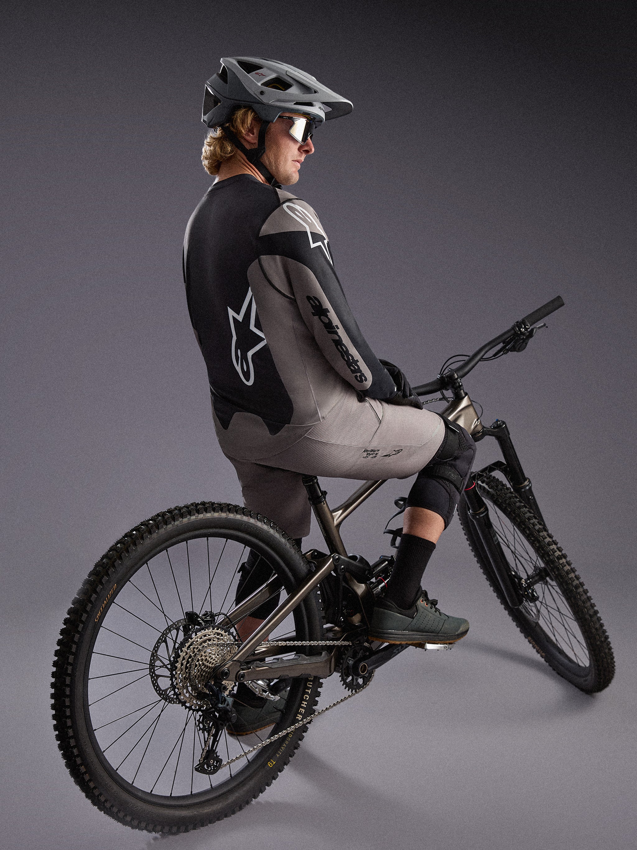 Gray A-Dura Race Long Sleeve Jersey on a mountain biker, featuring bold Alpinestars logos and performance stretch fabric.
