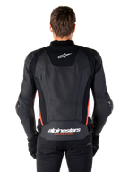 Alpinestars Missile V3 Leather Jacket, back view, premium black leather with red fluo and white accents, featuring a white star logo on the upper back and Alpinestars branding on the lower back, worn with black pants and gloves.