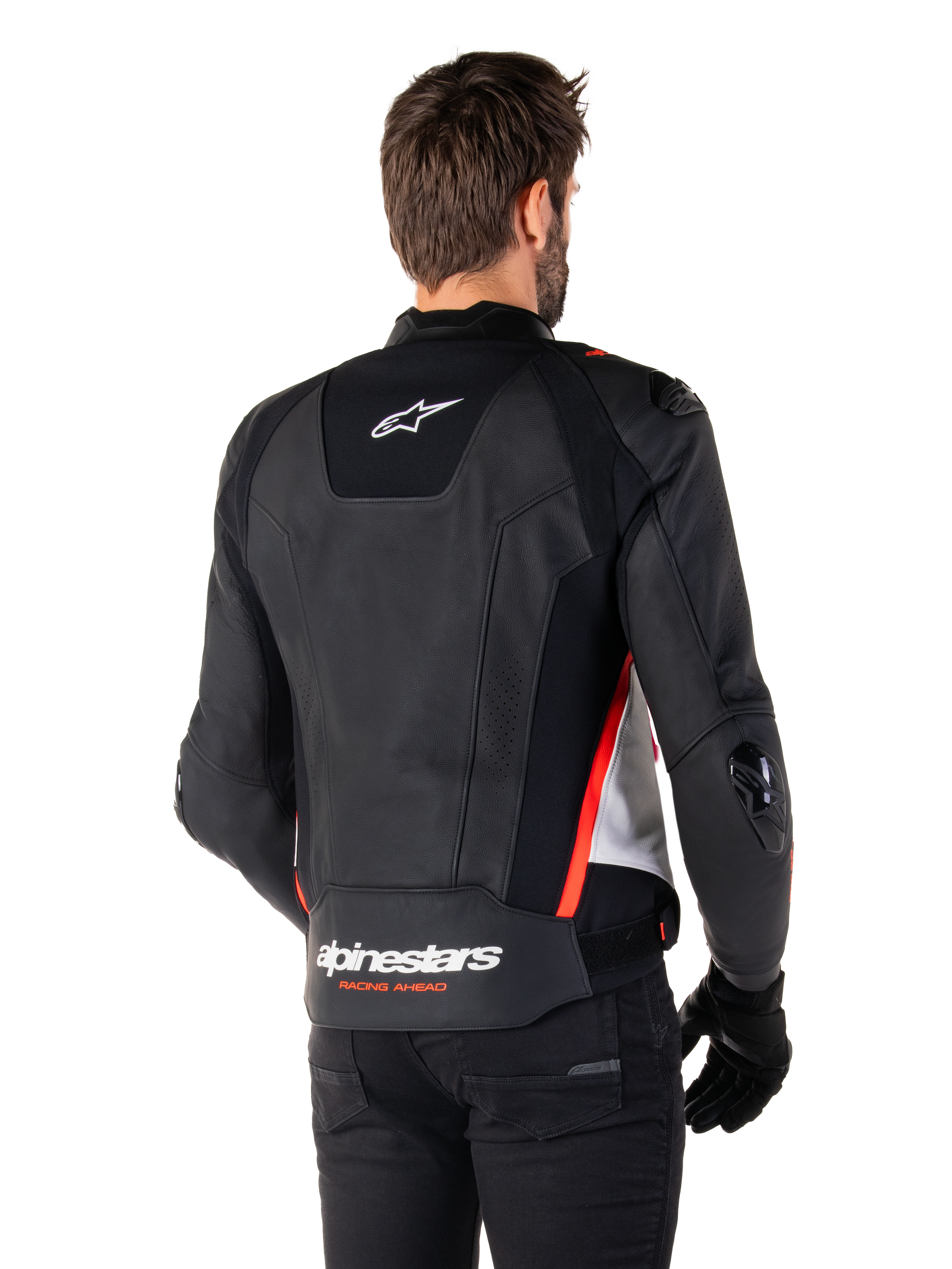 Alpinestars Missile V3 Leather Jacket, back view on a rider, Black White and Red Fluo, featuring bold Alpinestars branding and 'RACING AHEAD' text on the lower back, premium leather construction with technical stretch panels and protective TPU sliders, worn with black gloves and trousers.