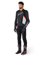 Male model wearing Alpinestars Missile V3 Leather Jacket in Black White and Red Fluo, paired with black motorcycle pants, gloves, and boots, featuring premium bovine leather construction with prominent Alpinestars branding, professional racing sport aesthetic
