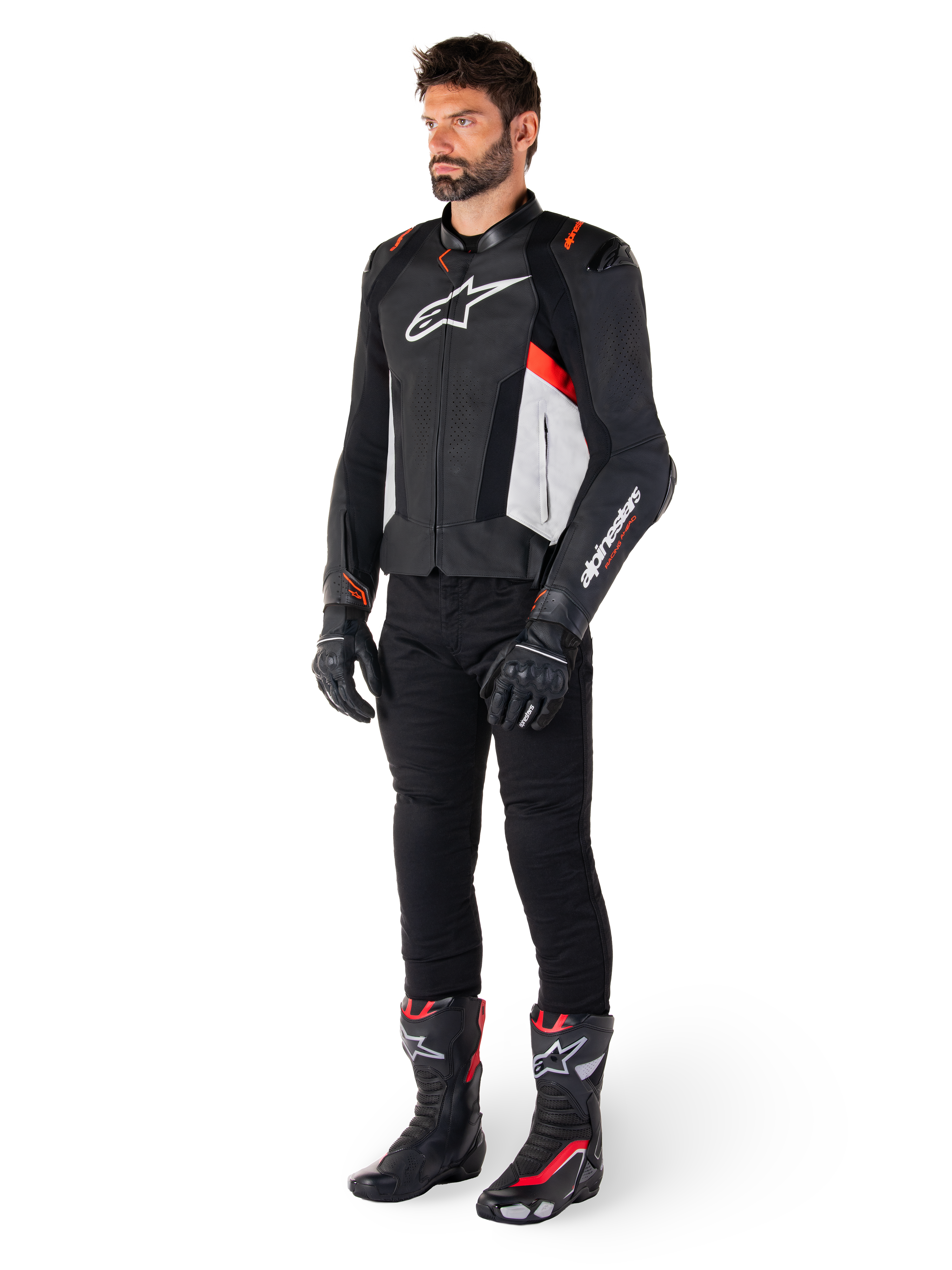 Male model wearing Alpinestars Missile V3 Leather Jacket in Black White and Red Fluo, paired with black motorcycle pants, gloves, and boots, featuring premium bovine leather construction with prominent Alpinestars branding, professional racing sport aesthetic