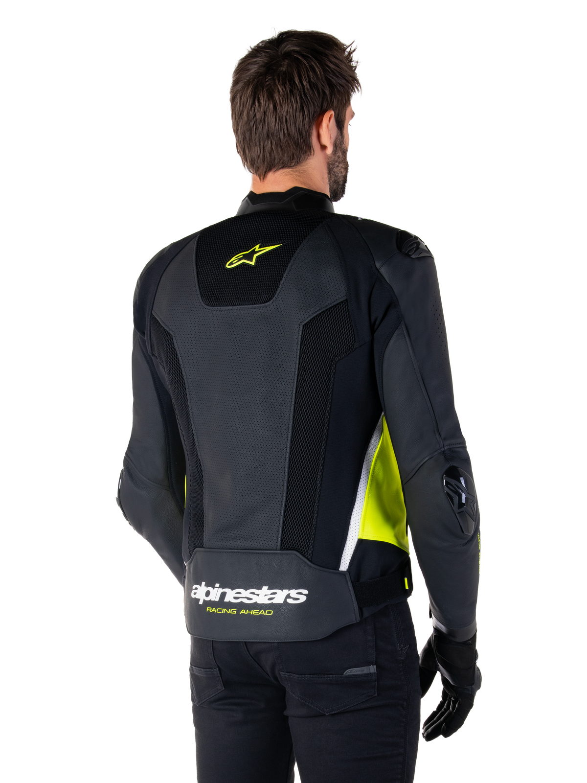 Alpinestars Missile V3 Airflow Leather Jacket, rear view on a male model, black with fluorescent yellow and white accents, featuring extensive perforated leather and mesh panels on the back, branded with a yellow star logo and white 'RACING AHEAD' text, paired with black gloves and pants.
