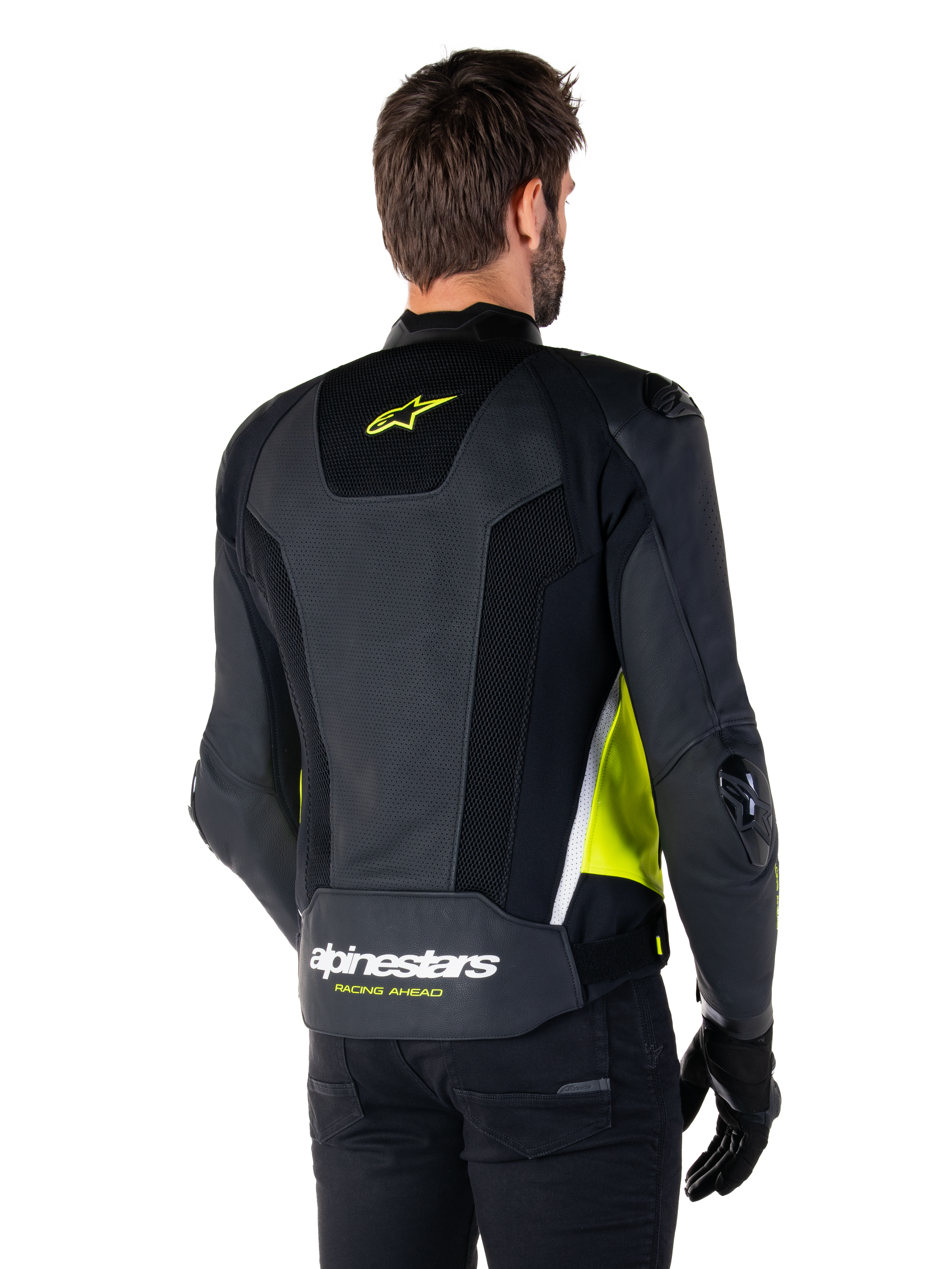 Alpinestars Missile V3 Airflow Leather Jacket, rear view on a male model, black with fluorescent yellow and white accents, featuring extensive perforated leather and mesh panels on the back, branded with a yellow star logo and white 'RACING AHEAD' text, paired with black gloves and pants.
