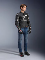 Alpinestars GP Plus R V4 Rideknit Leather Jacket, Black and White, motorcycle leather jacket worn by a model with blue jeans and black gloves, featuring a prominent white Astars logo on the chest, perforated panels, and white accents on the shoulders.