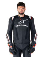 Alpinestars Missile V3 Ignition Leather Jacket, Black with white and red accents, worn by a male model with matching racing gloves and pants, MotoGP-derived sport motorcycle jacket with bold branding