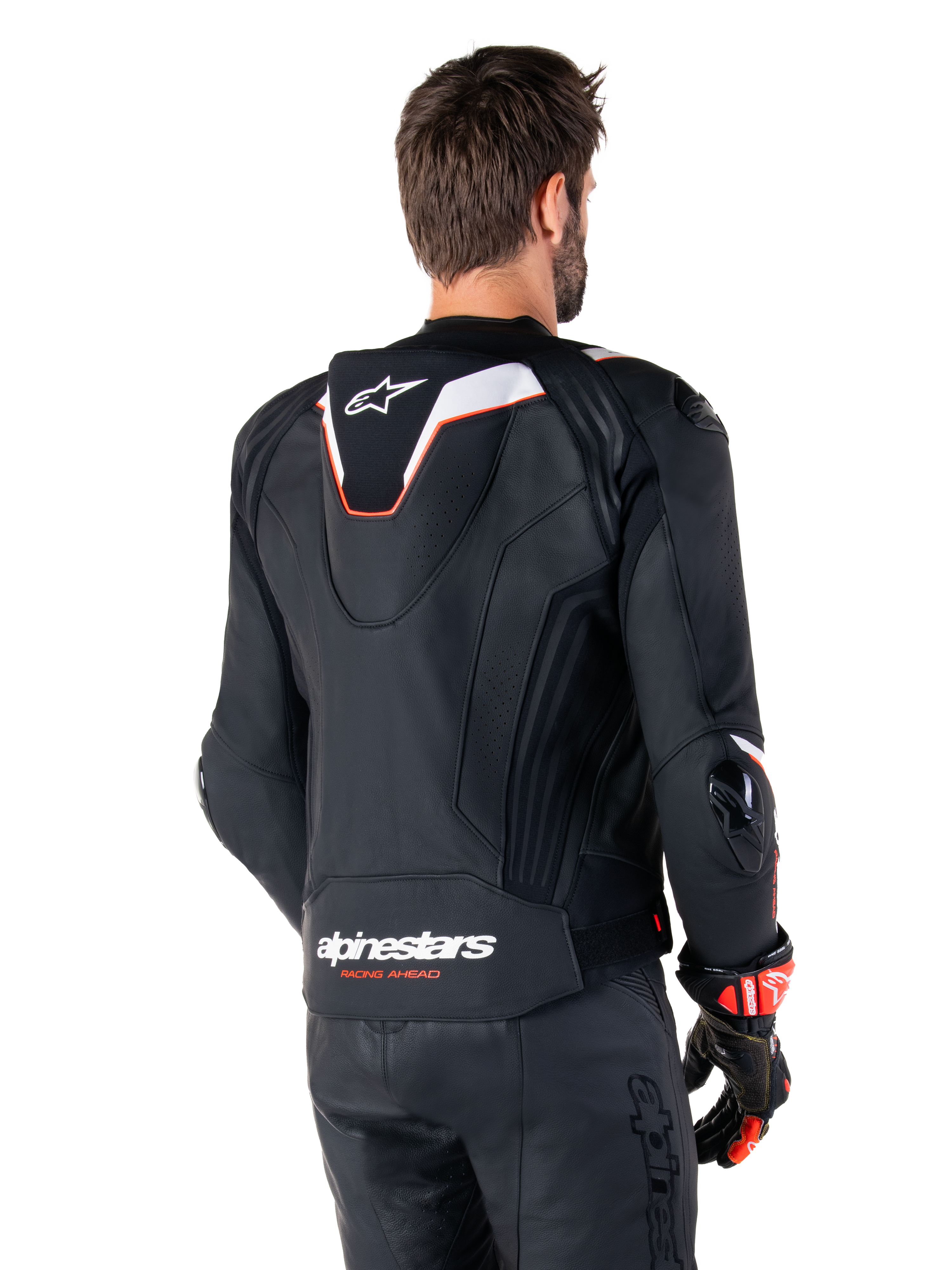 Alpinestars Missile V3 Ignition Leather Jacket, Rear View, Black with White and Red accents, featuring a slim sport Aero-hump and Alpinestars branding, worn with matching leather pants and racing gloves
