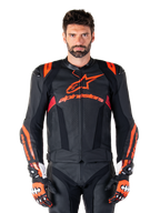 Alpinestars Missile V3 Ignition Leather Jacket, Motorcycle Racing Jacket, Black and Red Fluo, worn with matching racing gloves and leather pants, featuring perforated ventilation and prominent Alpinestars branding, professional racing gear