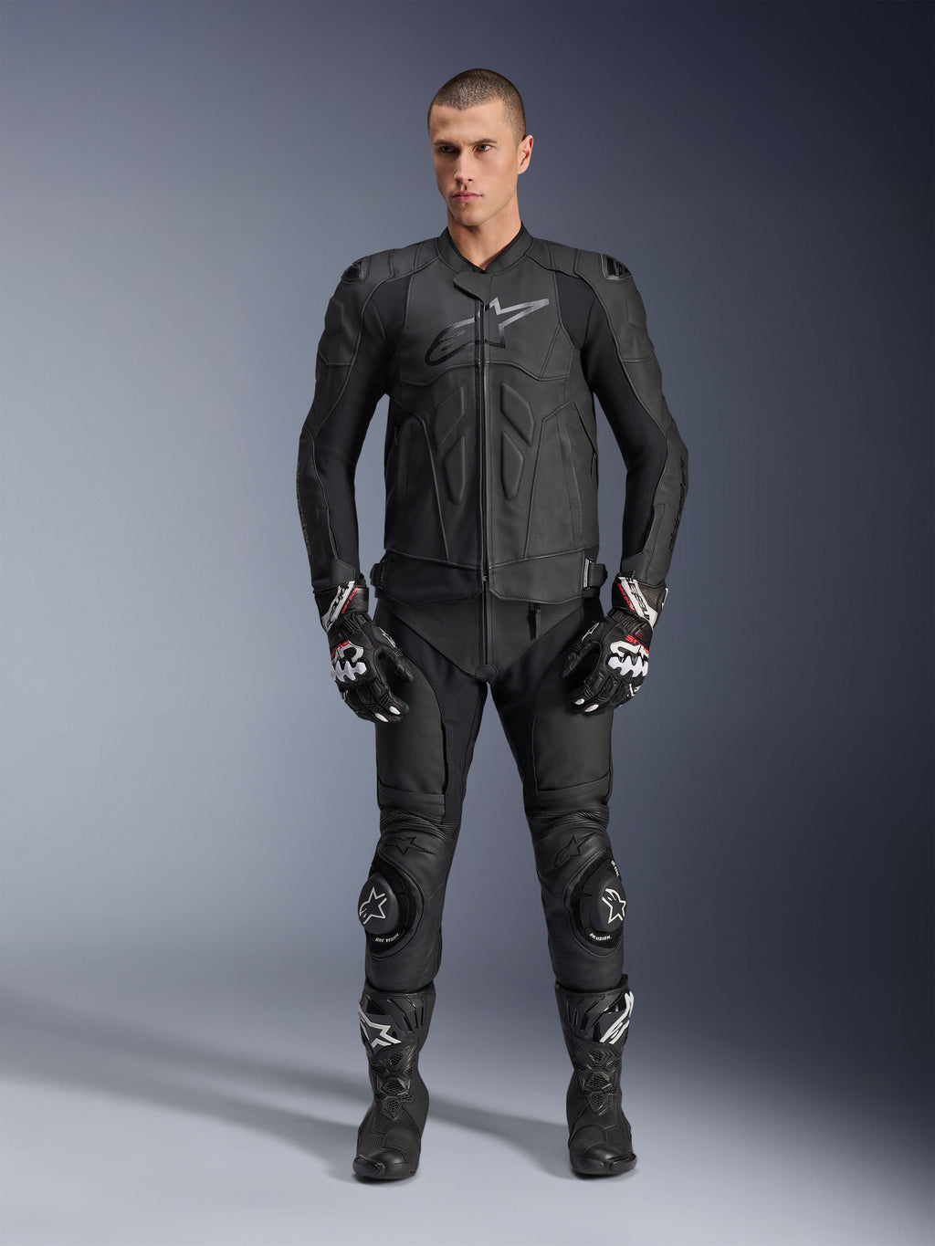 Alpinestars Dusk Leather Jacket, black bovine leather sport motorcycle jacket, worn by male model in full racing gear.
