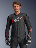 Alpinestars Dusk Airflow Leather Jacket, Black with Red Fluo and White accents, Leather Motorcycle Racing Jacket, featuring extensive perforations for ventilation, white chest logo, and external shoulder sliders, worn by a model with matching racing gloves