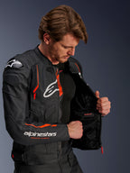 Alpinestars Dusk Airflow Leather Jacket, Black and Red Fluo, worn by a male rider, partially unzipped to show the interior mesh lining and waterproof pocket, featuring perforated leather for ventilation and bold branding on the chest and arm.