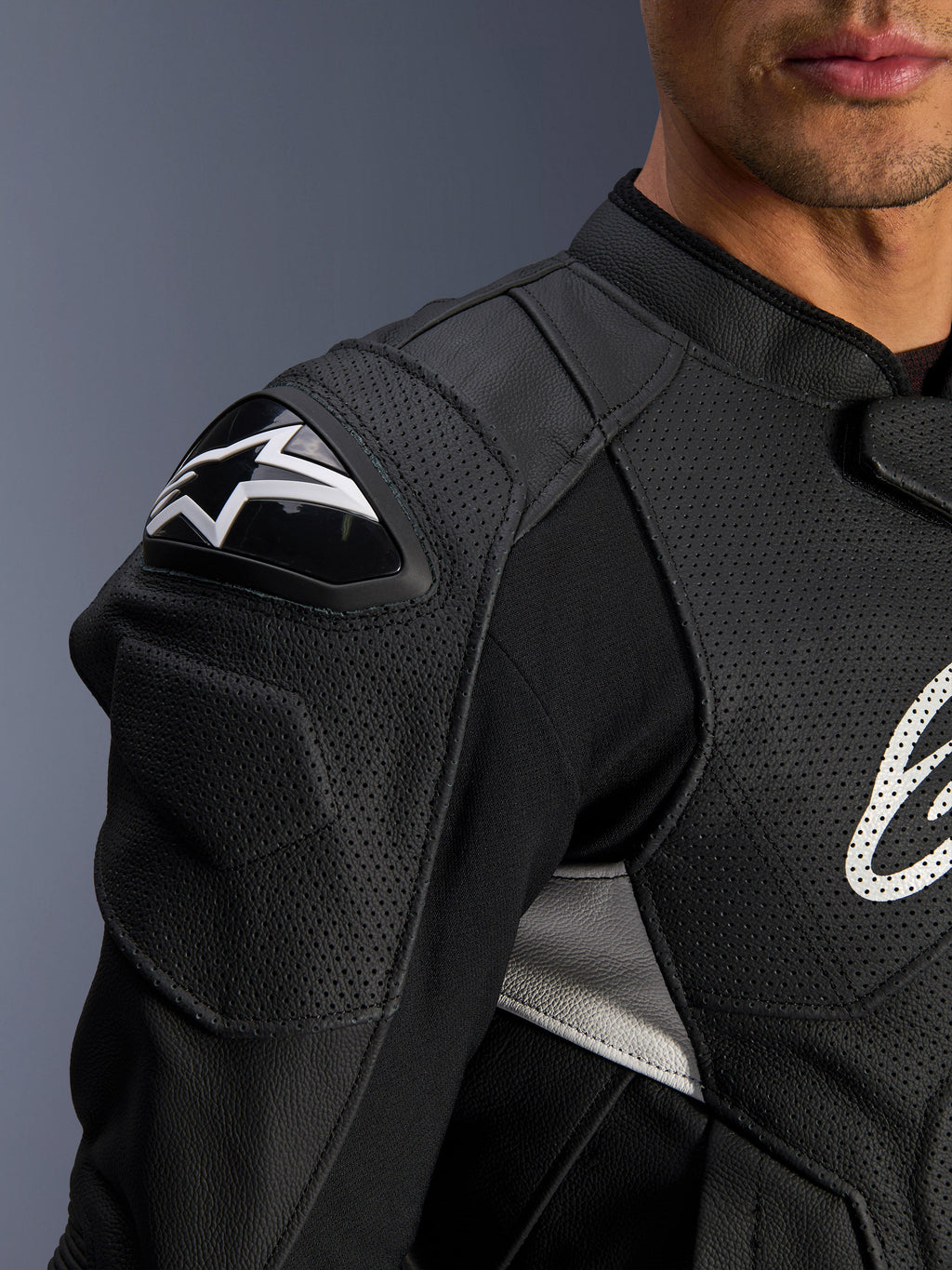 Alpinestars Dusk Airflow Leather Jacket, Black and White, close-up view of the shoulder and chest, featuring perforated leather for ventilation, DFS shoulder protection with white Alpinestars logo, and sporty design.