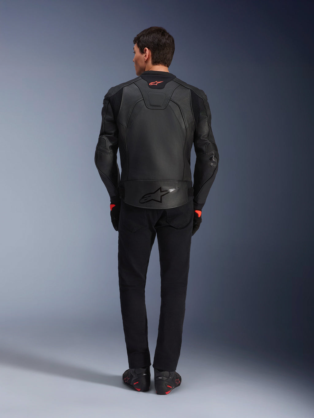 Alpinestars GP Plus R V4 Airflow Leather Jacket, Black, back view of rider wearing complete gear, features perforated leather for ventilation and red logo accents, sleek sport-fit design, paired with black pants and riding boots
