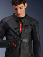 Alpinestars GP Plus R V4 Airflow Leather Jacket in Black, male model partially unzipping the front to show orange internal branding, featuring perforated leather panels and a glossy chest logo, paired with a black and red motorcycle glove