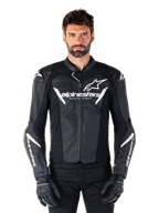 Alpinestars Faster V3 Leather Jacket, Black and White Motorcycle Racing Jacket, featuring bold white logos and 'Racing Ahead' chest text, sleek leather design with angular accents on sleeves, worn with black racing gloves