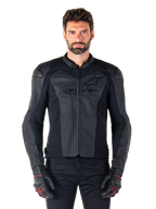 Man wearing Alpinestars Faster V3 Airflow Leather Jacket, Black motorcycle racing jacket with perforated leather panels, featuring Alpinestars logo on the chest, paired with black riding gloves, front-facing studio shot.