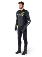 Male rider wearing the Alpinestars Faster V3 Airflow Leather Jacket in Black White and Yellow Fluo, paired with black motorcycle pants and boots, featuring perforated leather panels, white logo details, and neon yellow accents, professional sport riding gear