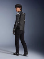 Male model wearing the Alpinestars Atem V5 Leather Jacket in Black and White, three-quarter rear view showing the aerodynamic speed hump and DFS RR protectors, styled with black pants, racing gloves, and boots, professional motorcycle racing apparel