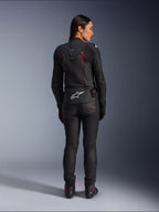 Alpinestars Stella Dusk Leather Jacket, rear view, black leather with Diva Pink and White accents, features white Alpinestars logo on lower back and pink vent details, worn with black riding pants and boots, premium sport motorcycle gear for women