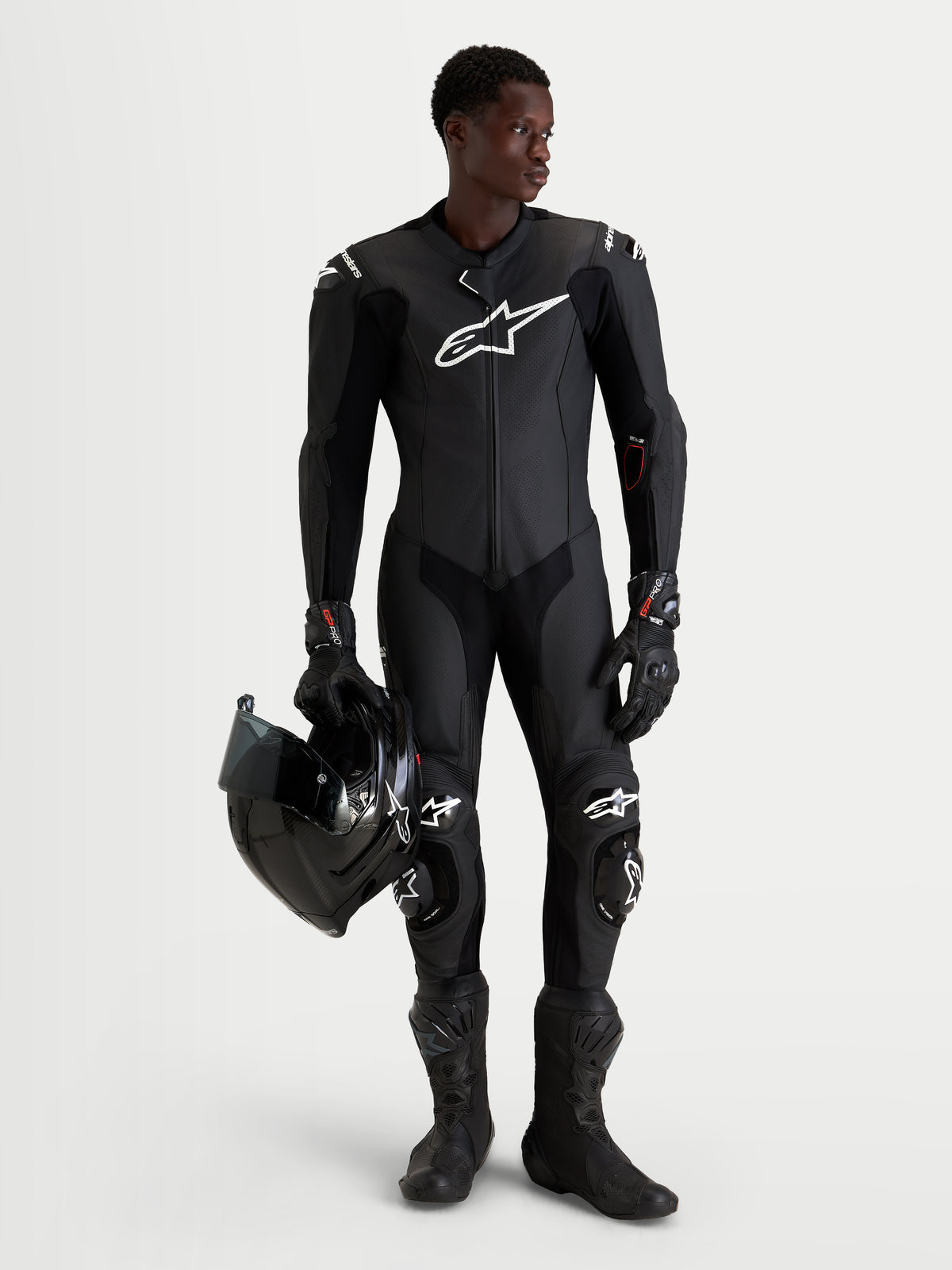 Alpinestars Missile V3 Leather Suit 1-Piece, Black men's 1-piece motorcycle racing leather suit with integrated DFS ST armor and CE AAA certification, worn by a model holding a helmet
