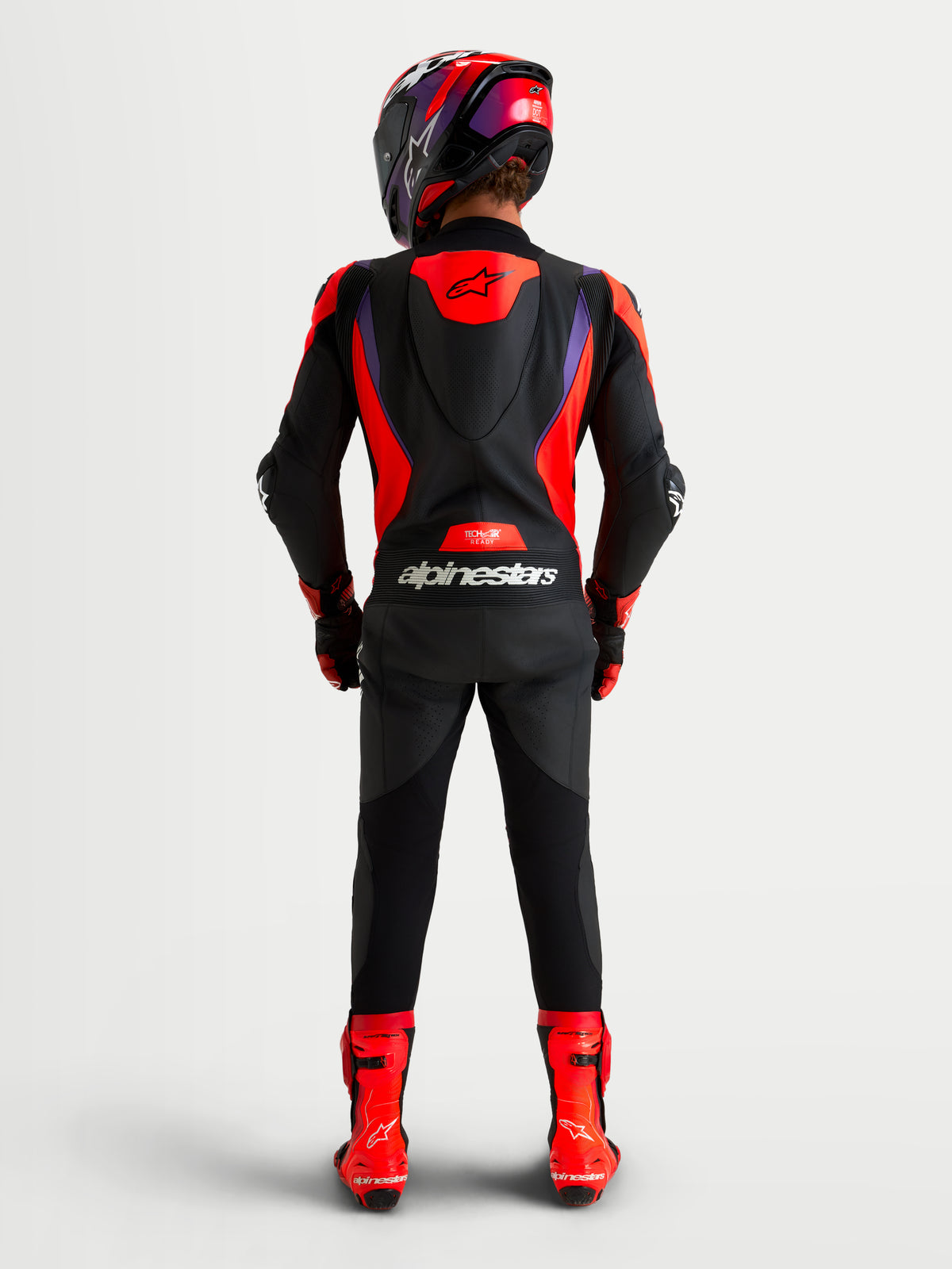 Alpinestars Missile V3 Leather Suit 1 Piece, men's AAA-rated racing leather suit, Black, Red, and Purple, featuring an aerodynamic speed hump and CE certified protection, shown from the rear view worn with matching helmet and boots