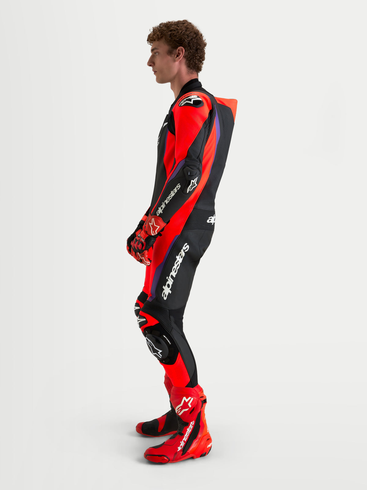 Alpinestars Missile V3 Leather Suit - 1 Piece, men's AAA-rated motorcycle racing leather suit, Black, Red, and Purple, featuring integrated DFS armor and aerodynamic speed hump, worn by a model in profile view
