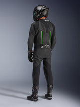 Rider from behind wearing Alpinestars GP Force V2 Leather Suit, 1-Piece, Black with Green accents, aerodynamic speed hump, paired with a black carbon-fiber helmet, black racing boots, and gloves, high-performance motorcycle racing gear