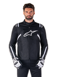 Alpinestars T-SPS V2 Waterproof Jacket in Black and White, front view on model, waterproof textile motorcycle jacket featuring white shoulder and arm stripes, large white Alpinestars logo on chest, worn with protective motorcycle gloves, sleek sport-inspired silhouette