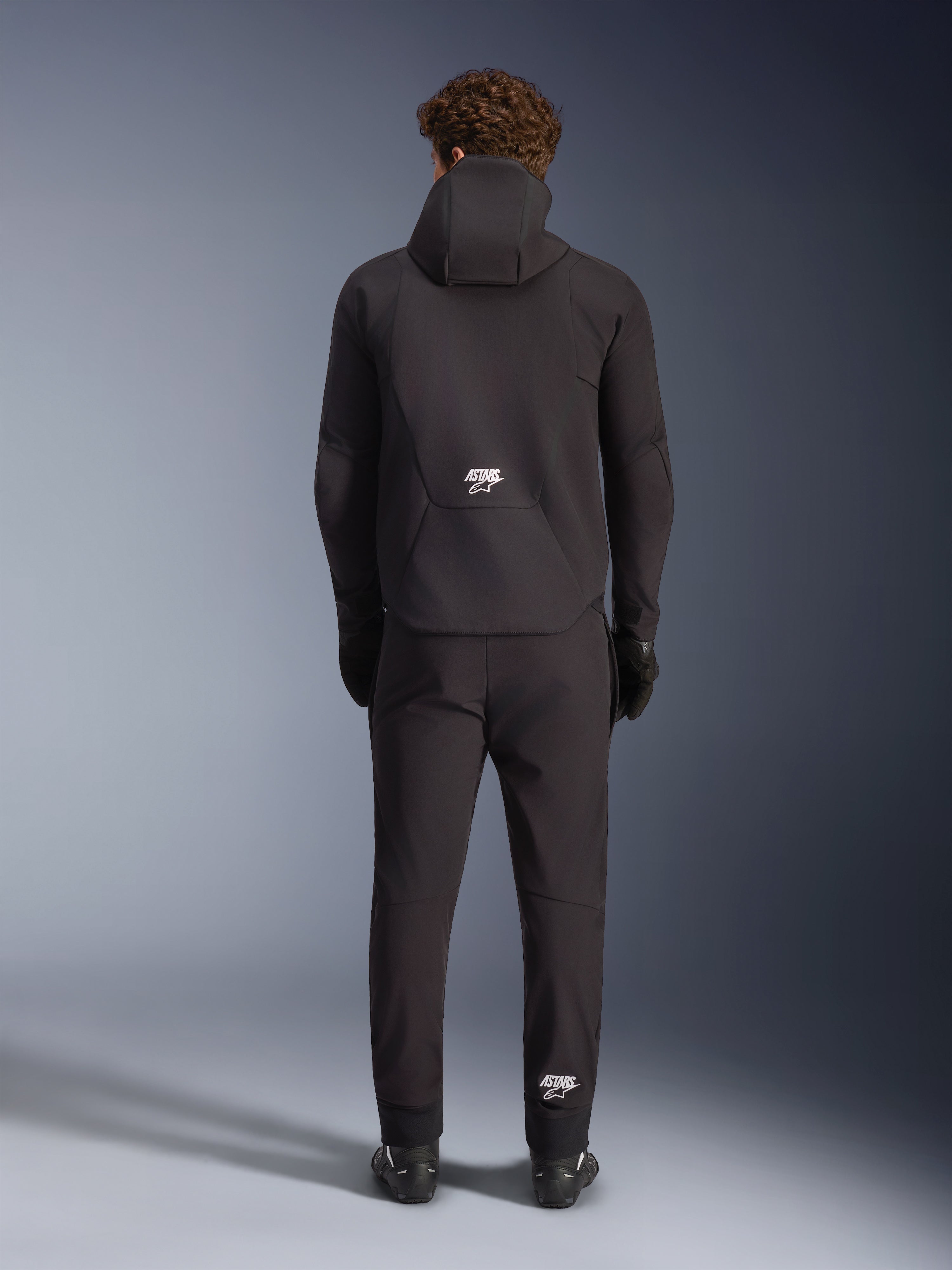 Alpinestars Aeroshell Waterproof Jacket, black men's motorcycle softshell hoodie, back view with white ASTARS logo.