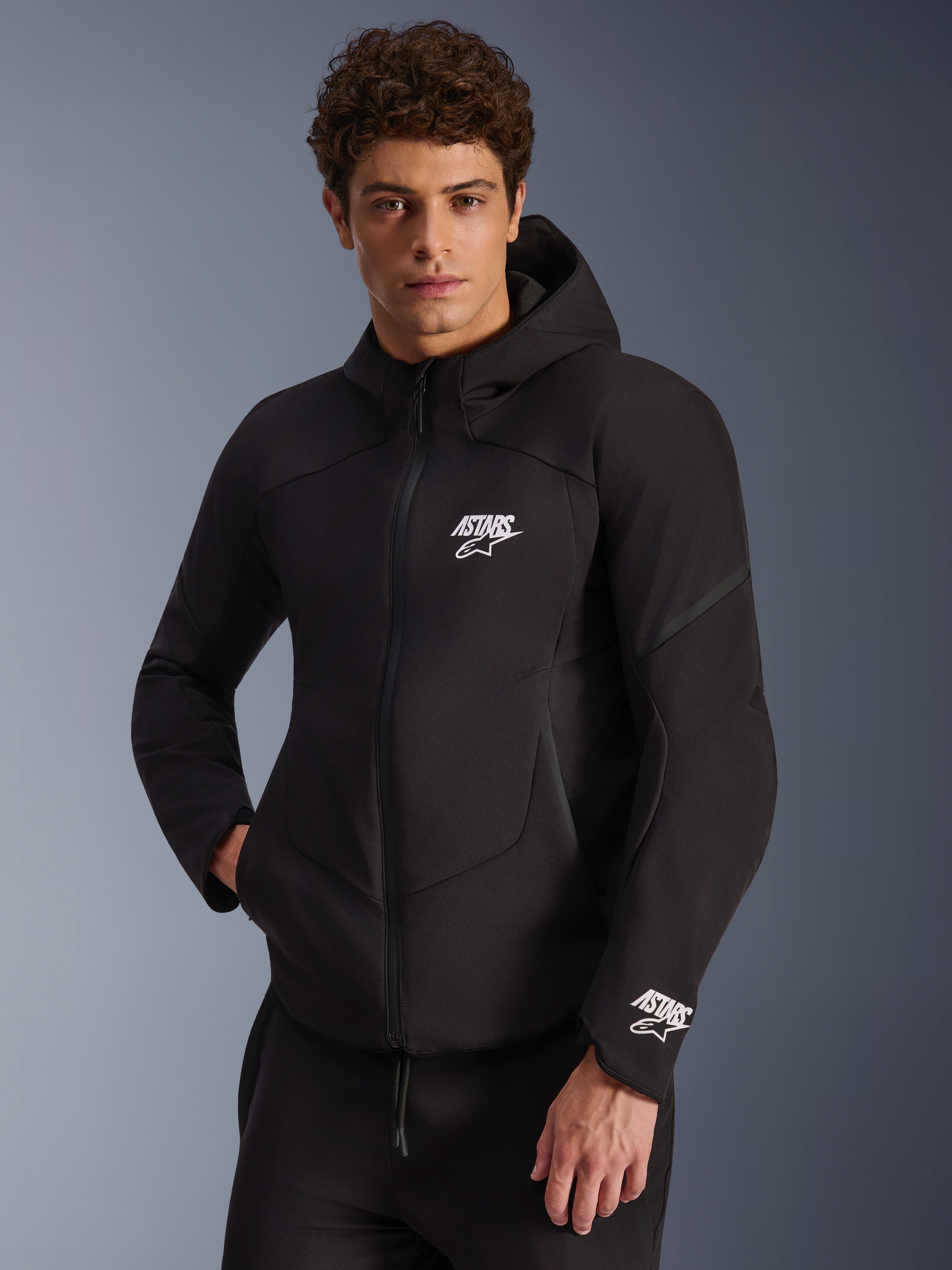 Alpinestars Aeroshell Waterproof Jacket, men's black softshell motorcycle jacket with white ASTARS logos and integrated hood.