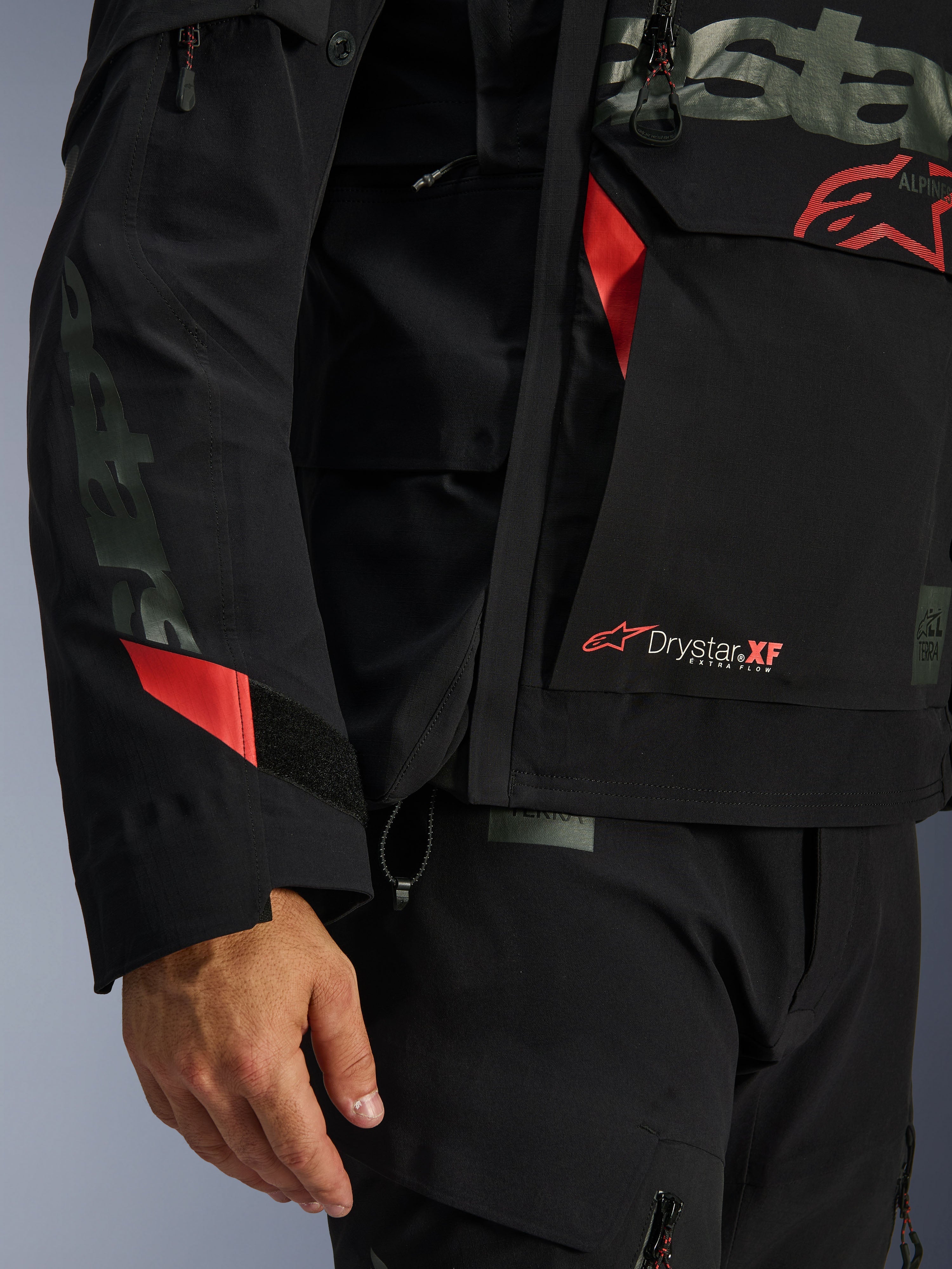 Alpinestars Halo Pro Drystar® XF Laminated Jacket, Motorcycle Jacket, Black with red accents, close-up featuring Drystar® XF branding, technical laminated shell texture, and adjustable sleeve details for adventure riding