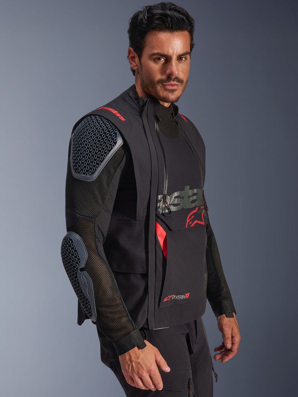 Alpinestars Halo Pro Drystar® XF Laminated Jacket, Black and Dark Shadow, adventure motorcycle jacket worn by model, modular configuration featuring mesh sleeves with integrated shoulder and elbow armor, red logo accents and technical waterproof zippers.