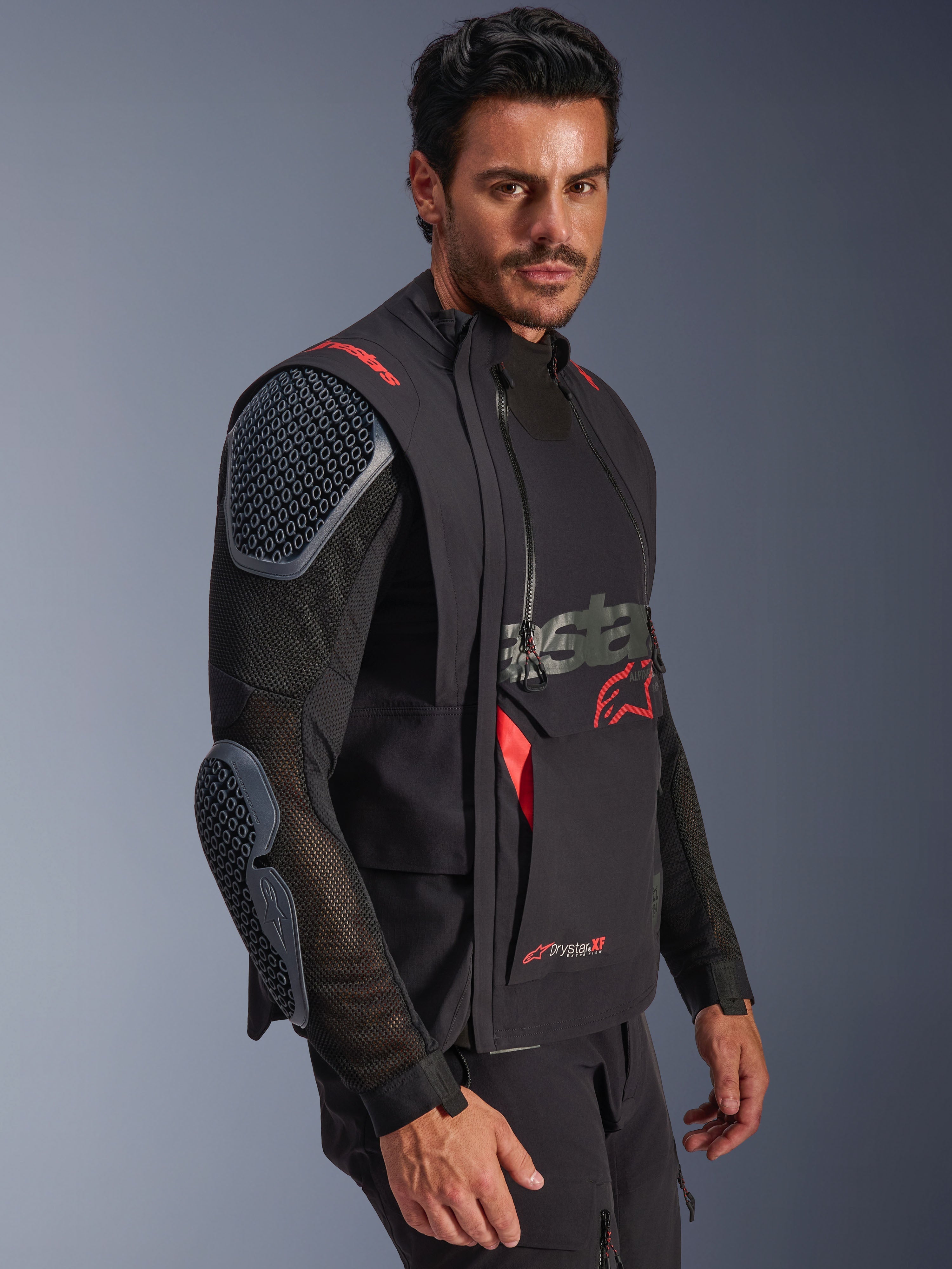 Alpinestars Halo Pro Drystar® XF Laminated Jacket, Black and Dark Shadow, adventure motorcycle jacket worn by model, modular configuration featuring mesh sleeves with integrated shoulder and elbow armor, red logo accents and technical waterproof zippers.