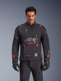 Alpinestars Halo Pro Drystar® XF Laminated Jacket, Adventure Motorcycle Jacket, Black Dark Shadow with red accents, male model wearing full technical gear including matching gloves and pants, front view highlighting modular chest ventilation panels and waterproof construction.