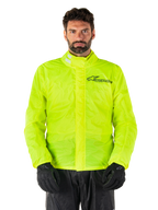 Alpinestars Hurricane Rain V2 Jacket, Motorcycle Rain Jacket, Yellow Fluo, worn by a model with black pants and gloves, high collar with reflective tabs, front storm flap with Alpinestars logo, high-visibility waterproof gear