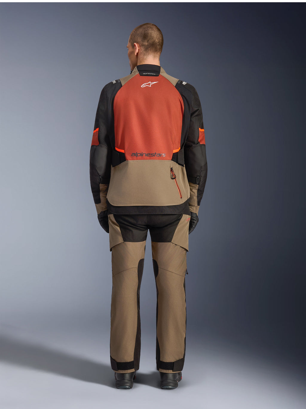 Alpinestars Andes V4 Drystar® Jacket, Walnut Rust Black, rear view of motorcycle touring jacket featuring rust-colored upper back panel and walnut lower section, worn with matching adventure pants and black boots