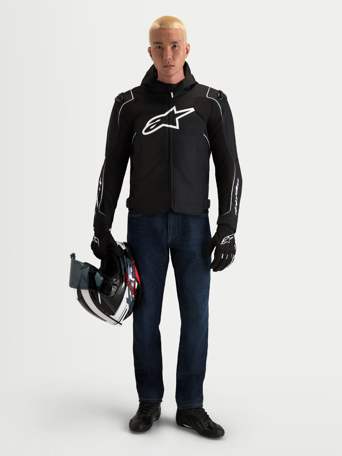 Alpinestars Zaca V2 Waterproof Jacket, Men's Black and White textile motorcycle riding jacket with integrated hood, worn by a model holding a helmet