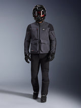 Alpinestars Maxdura Drystar®XF Laminated Armored Shell, adventure motorcycle jacket in Deep Gray and Black, worn with matching black riding pants, a black full-face helmet, gloves, and boots, featuring prominent cargo pockets and ALL TERRA branding for a technical off-road touring look