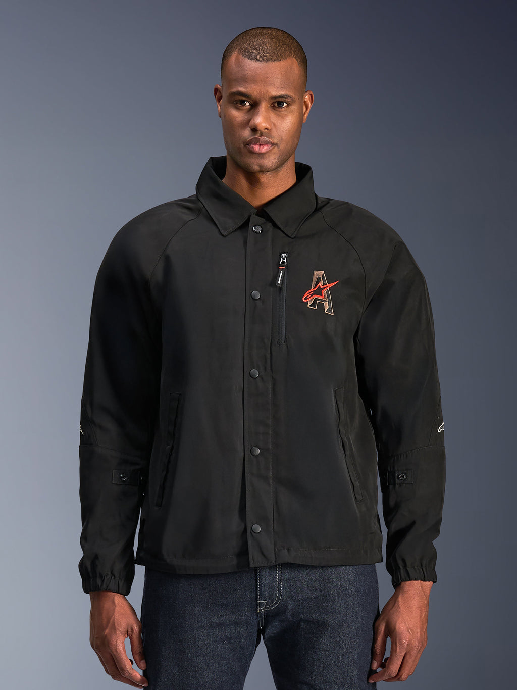Alpinestars Revved WR Jacket, Black Motorcycle Jacket, featuring a shirt-style collar and snap-button front, red embroidered 'A' logo on chest, vertical zippered chest pocket, elastic cuffs, urban coaches jacket design