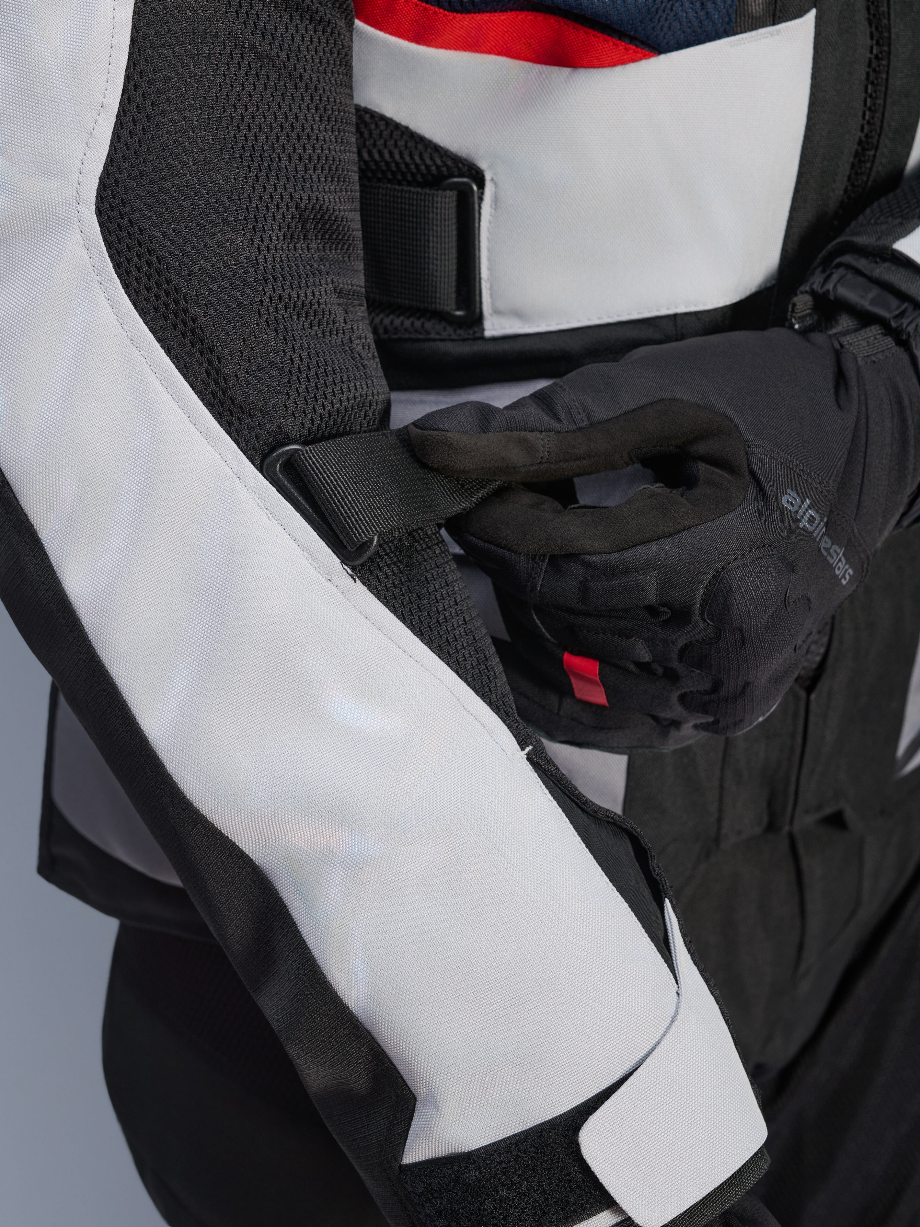 Alpinestars Andes Air Drystar® Jacket in Deep Blue Black Ice Gray, close-up view of the adjustable sleeve strap and mesh ventilation panels, featuring durable textile construction for adventure touring