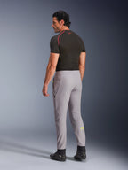 Alpinestars Aeroshell Pants, Mid Gray Yellow Fluo, back-side view of male model wearing stretch softshell motorcycle pants, features yellow Astars logo on the left calf, paired with a black base layer and riding shoes for a modern sports silhouette.