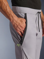 Alpinestars Aeroshell Pants, Mid Gray Yellow Fluo, close-up of zipped front pocket and waist, black taped zipper with yellow fluo tips, elastic waistband with black drawstring, crossover sports softshell motorcycle pants