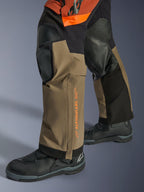Alpinestars Halo Pro Drystar® XF Laminated Pants, Adventure Motorcycle Pants, Walnut Rust and Black, detail shot featuring reinforced knee panels and orange branding, worn with black touring boots, durable textile construction for all-terrain riding