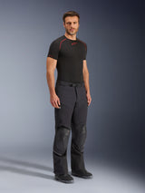Alpinestars Andes Pro Drystar® XF Pants, Black and Dark Gray adventure touring motorcycle pants, featuring reinforced knee protection zones, zippered pockets, and adjustable waist belt, shown on a model with black riding boots.